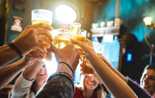 Pessoas brindando copos de cerveja