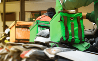 Entregadores com mochilas térmicas organizados para delivery de bebidas